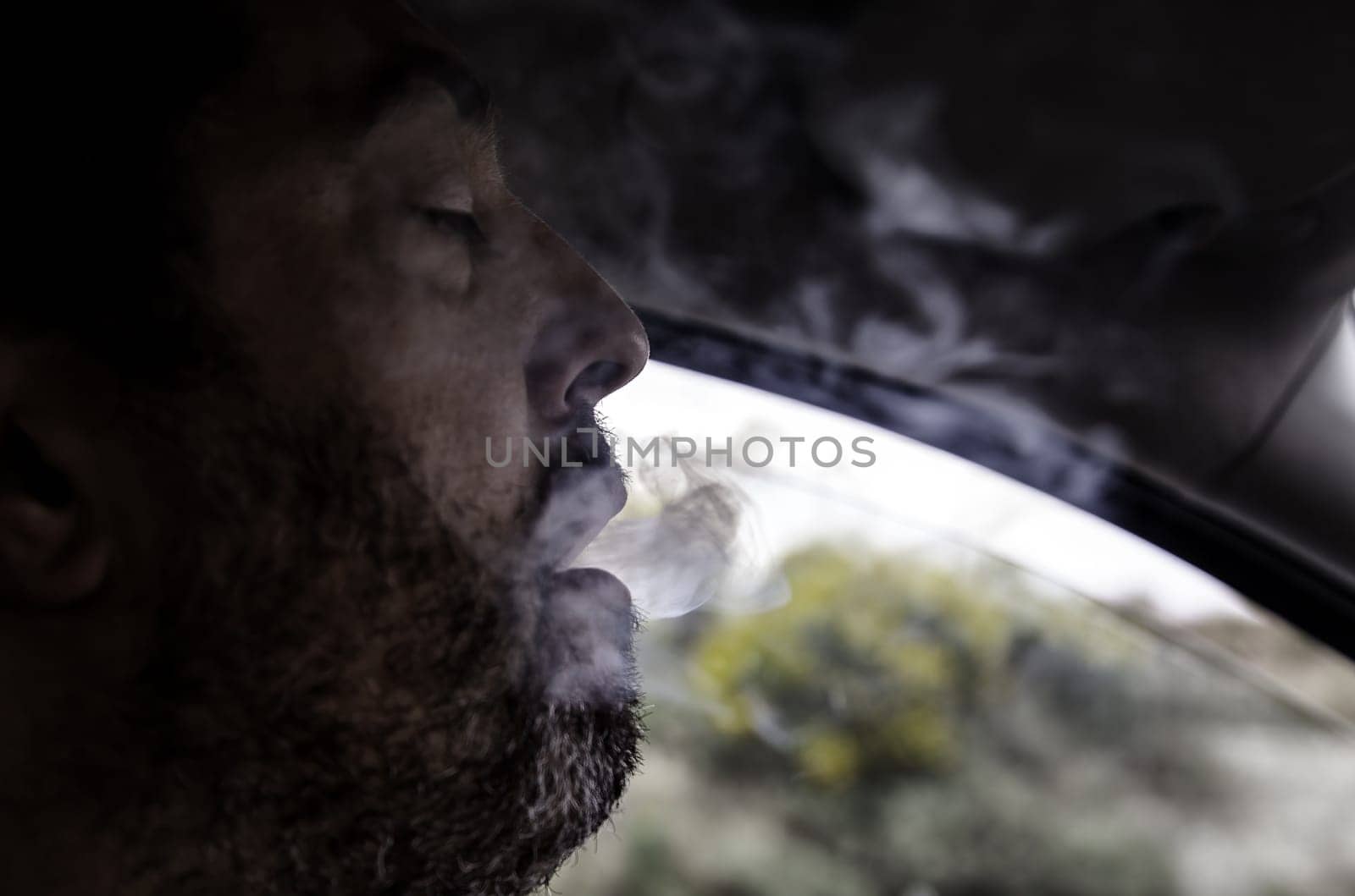 Detail of young person releasing smoke from the mouth, addiction, nicotine