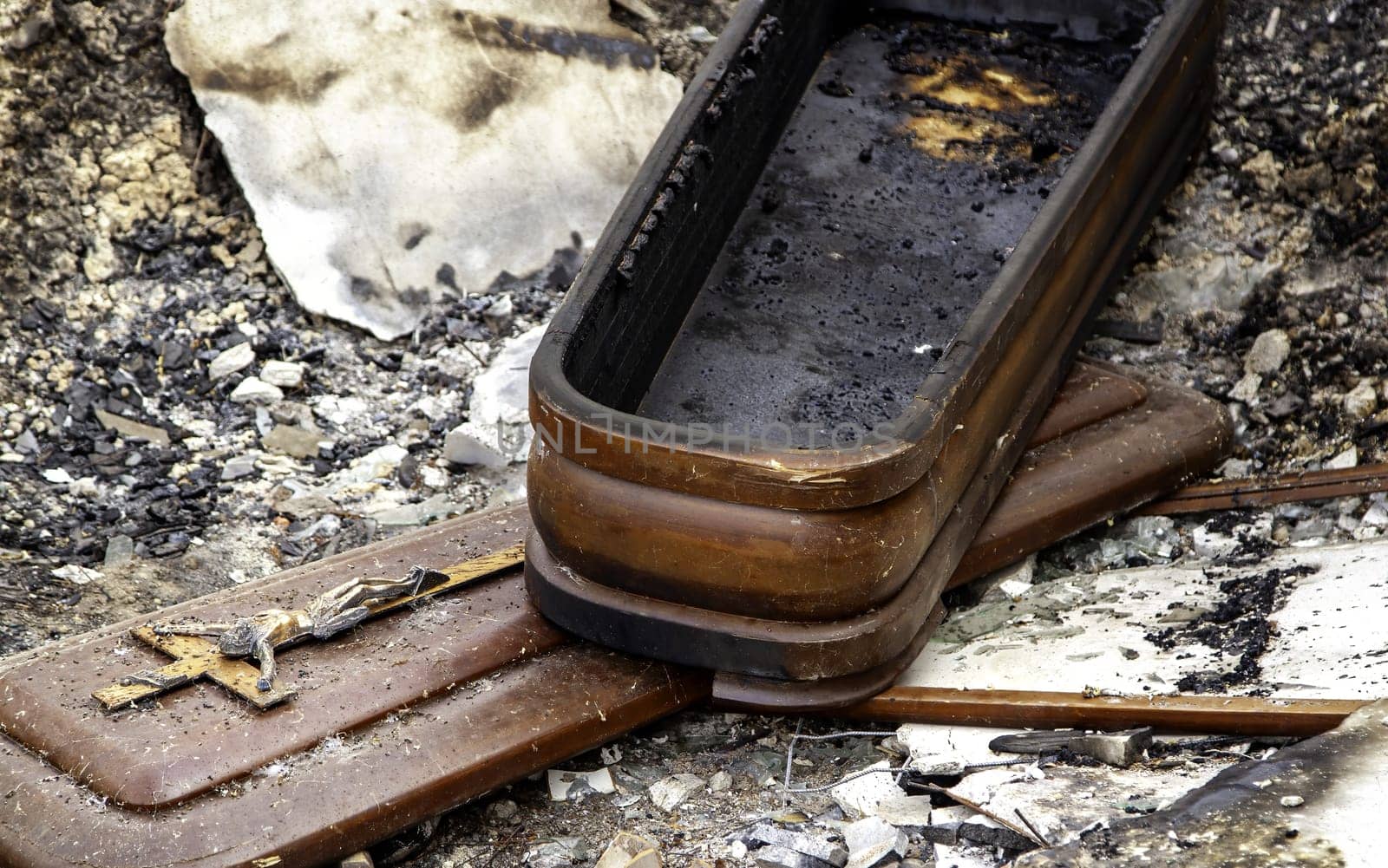 Burnt coffin wit0h flowers in cemetery, religion and burial