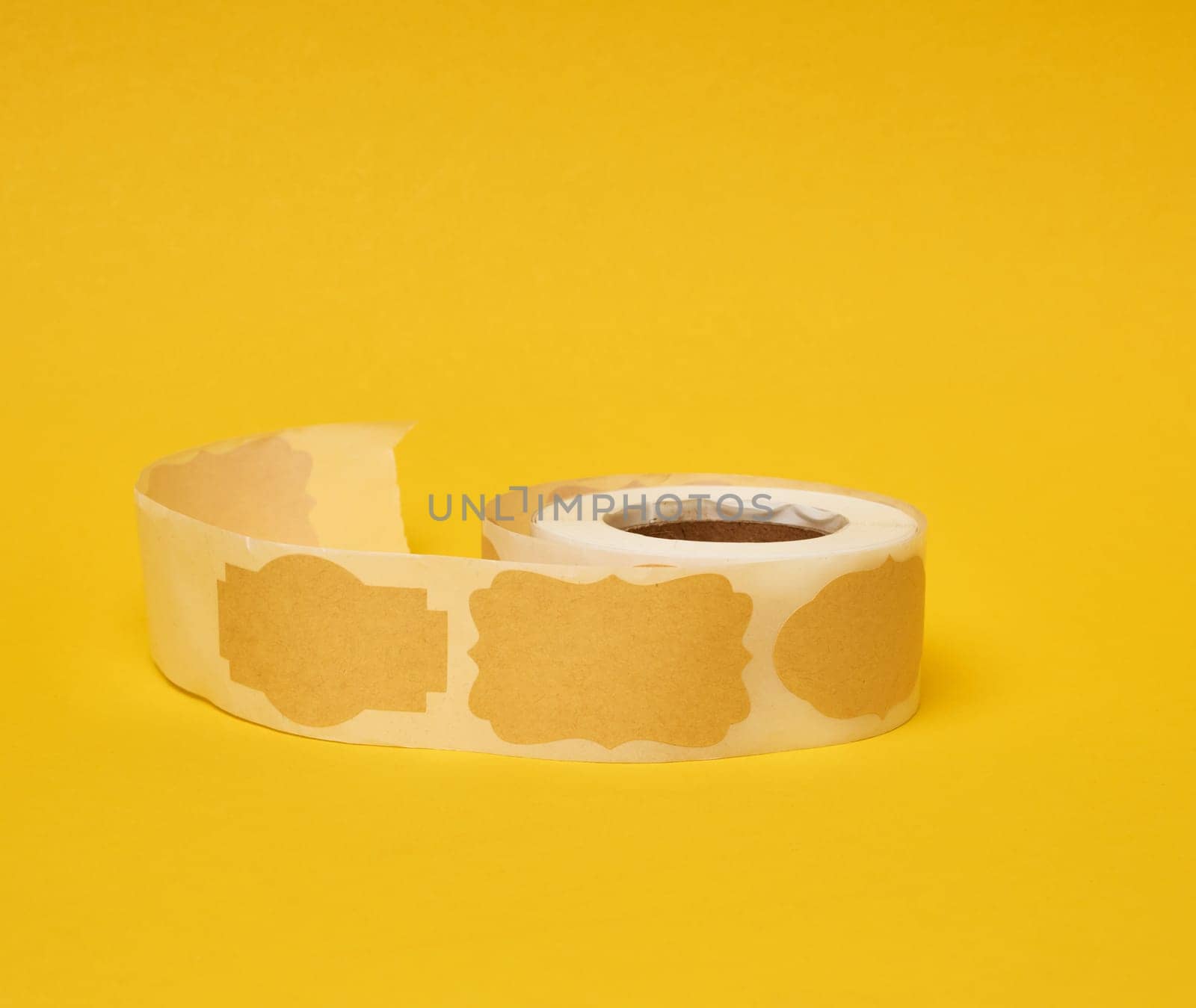 Sticky empty brown paper labels on tape, yellow background