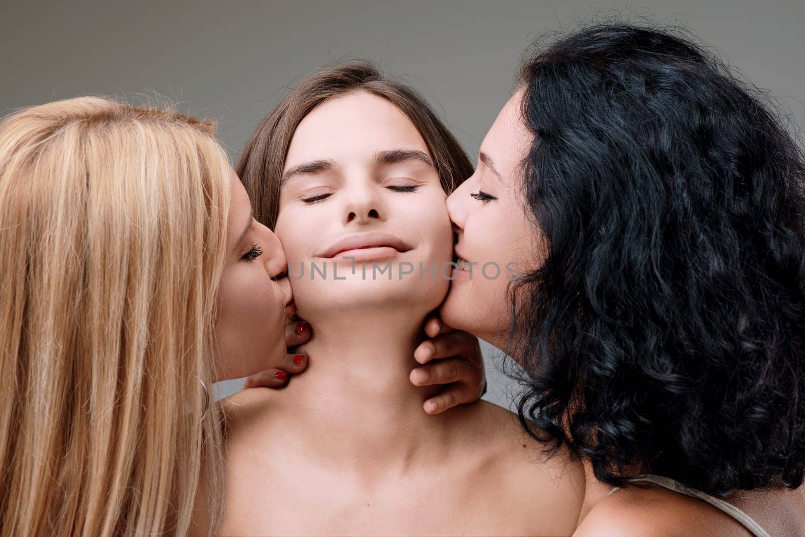 Three women sharing a tender moment, kissing each other on the forehead, showing love and friendship. Topless, hugging intimately, with blonde, brunette, and black hair