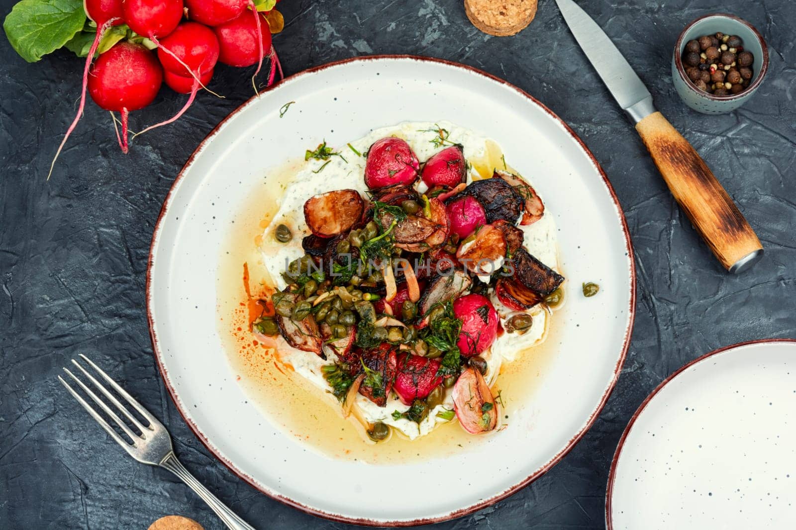 Roasted radish salad or piccata on a concrete kitchen table. Vegetarian piccata, Italian food.