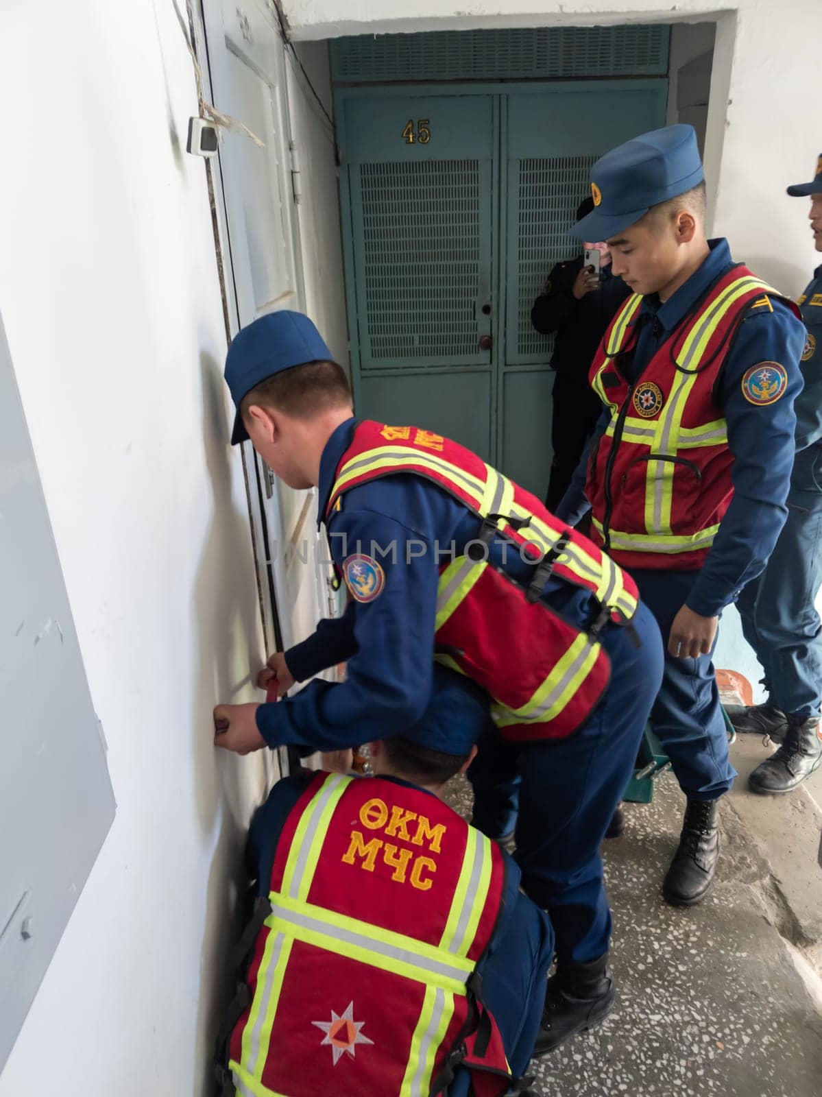 Rescuers from the Ministry of Emergency Situations of Kyrgyzstan break open a metal door to an apartment in an apartment building in Bishkek, Kyrgyzstan April 22, 2023