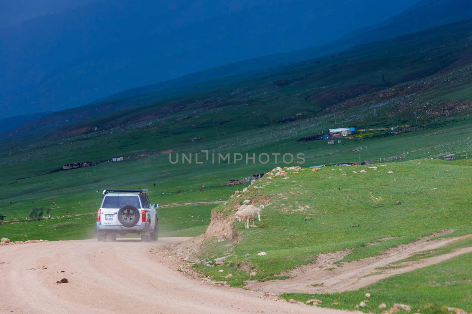 adventurous offroad journey through remote countryside in mountain ravine with dramatic pre-storm cloudy skies in Semenovskoye gorge, Kyrgyzstan at July 5, 2023