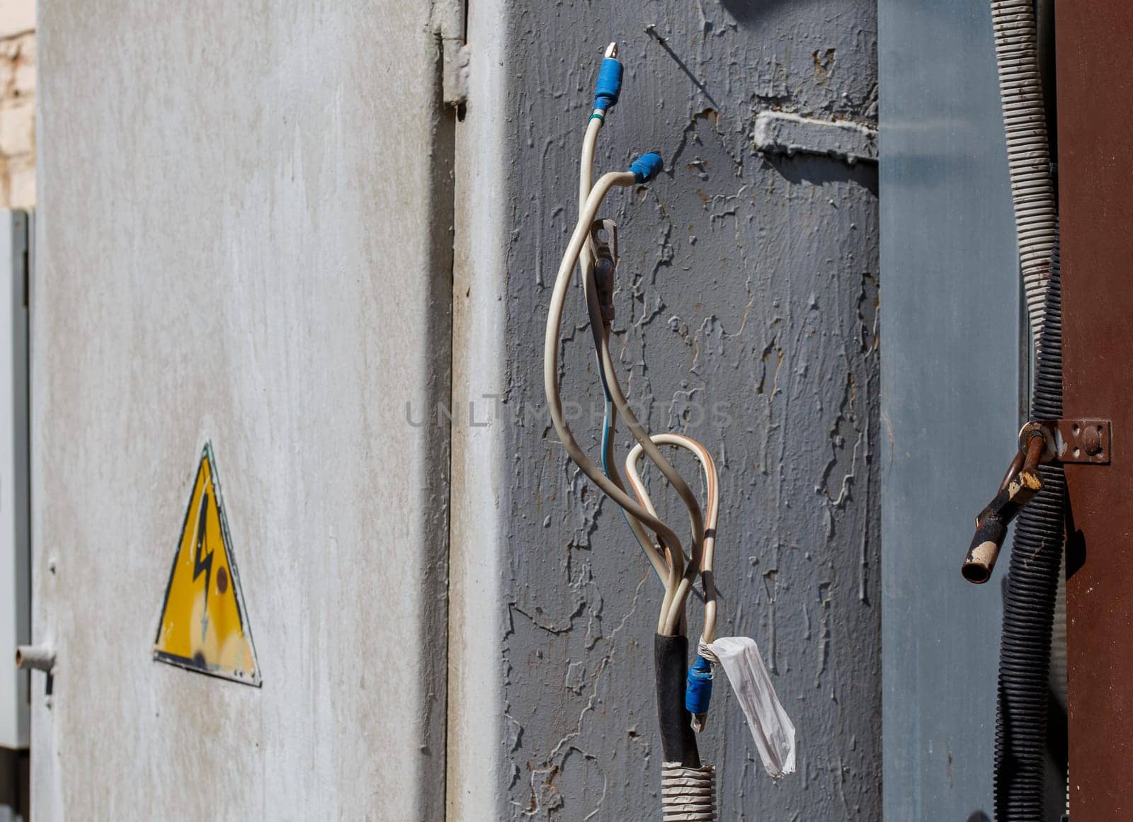 bare wire lugs in front of outdoors electrical box at sunny day, closeup with selective focus