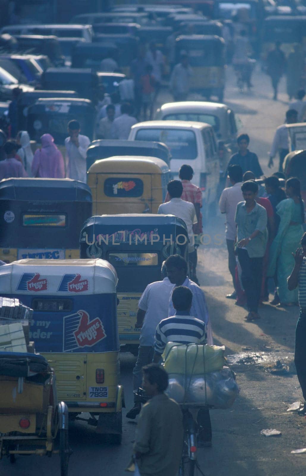 Traffic and pollution with cars, bus amd motorcycle on a mainroad in the city of Chennai in Province Tamil Nadu in India.  India, Chennai, April, 1998