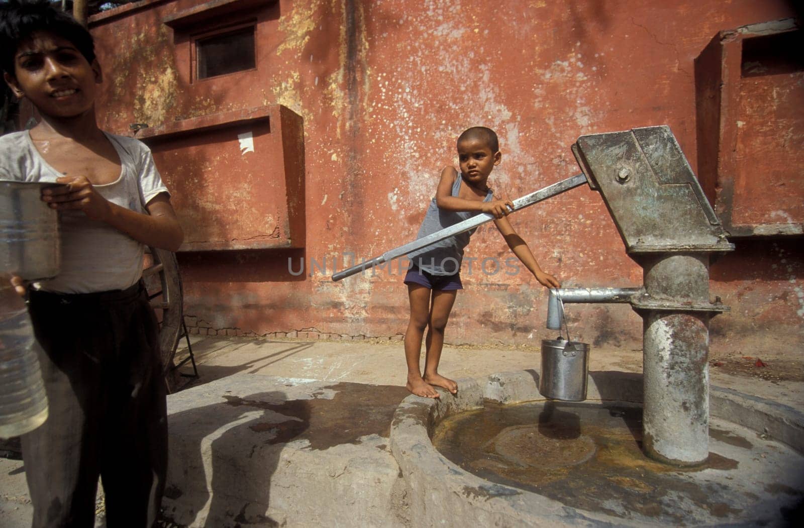 a free public water station for dursty people at a shop by very hot weather in the city of Khajurao in Province Madhya Pradesh in India.  India, Khajurao, April, 1998