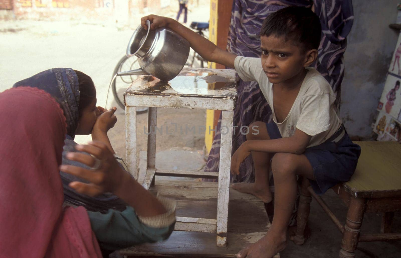 a free public water station for dursty people at a shop by very hot weather in the city of Khajurao in Province Madhya Pradesh in India.  India, Khajurao, April, 1998