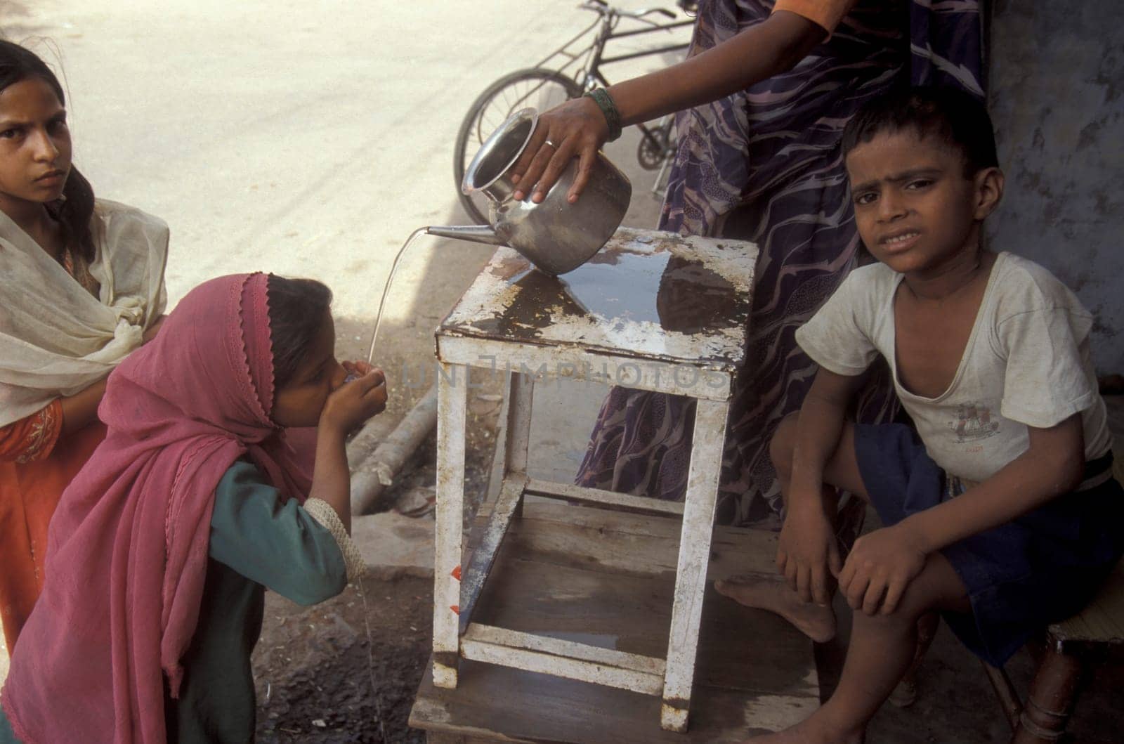 a free public water station for dursty people at a shop by very hot weather in the city of Khajurao in Province Madhya Pradesh in India.  India, Khajurao, April, 1998
