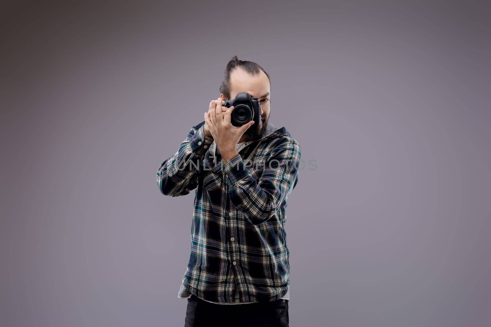 Confident photographer framing shot with professional camera in studio. Passionate hobbyist showcases creativity and skill