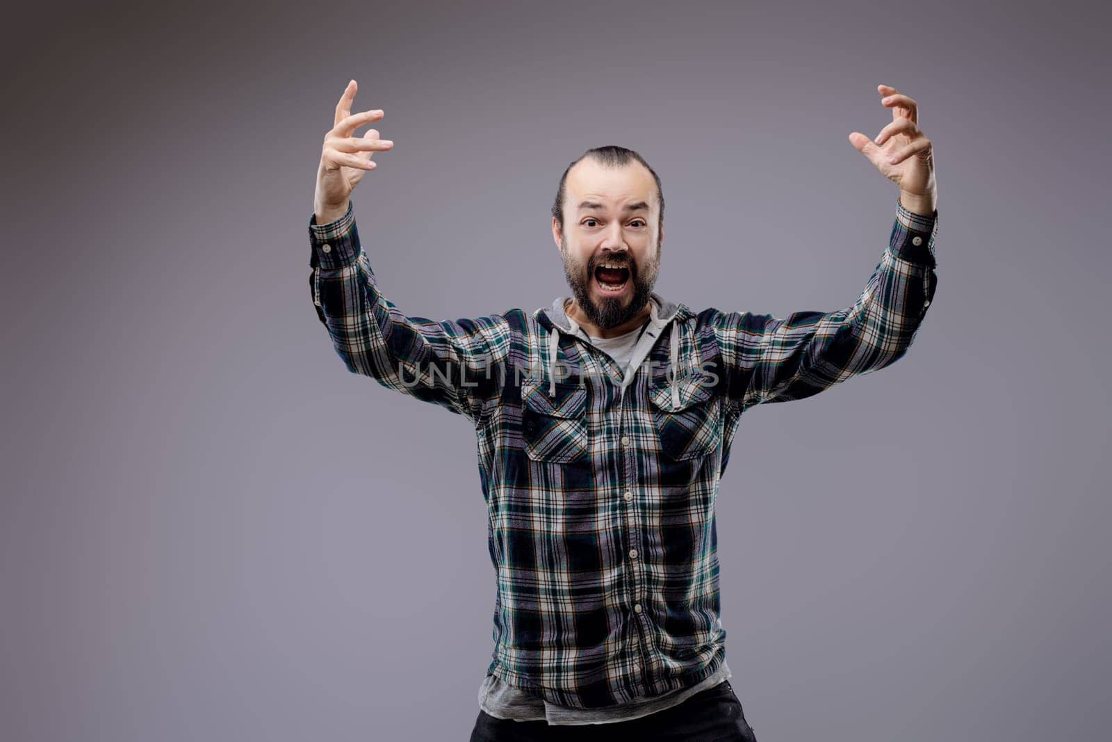 Frustrated man with a beard yells loudly, showing intense anger and stress. His emotional outburst captures raw human expression, highlighting mental health complexities