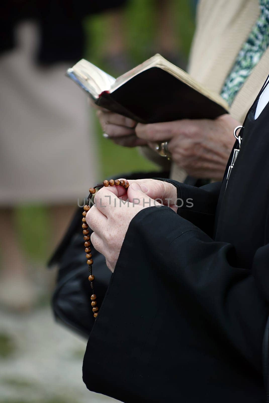 Hands of a woman holding a rosary while praying, Christian daily devotional of a worshiper of God the Savior, Basilica of Assumption of the Virgin Mary in Marija Bistrica, Croatia