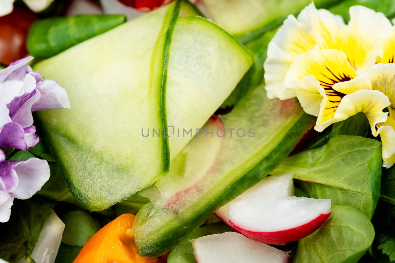 Fresh green salad of vegetables, edible flowers, field pansies, violets. Detox food