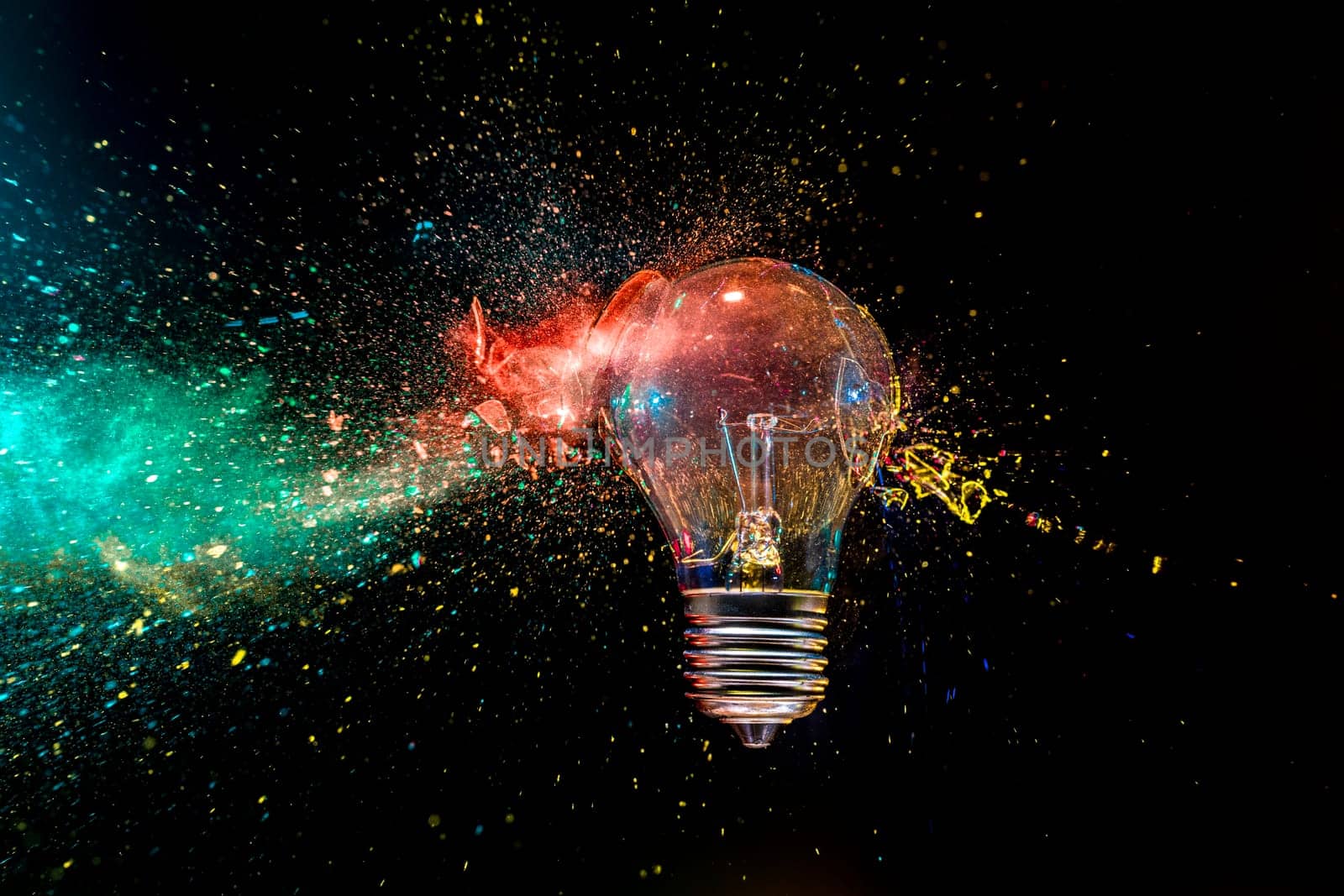 real image Light bulb  exploding colorful powder black background creativity concept
