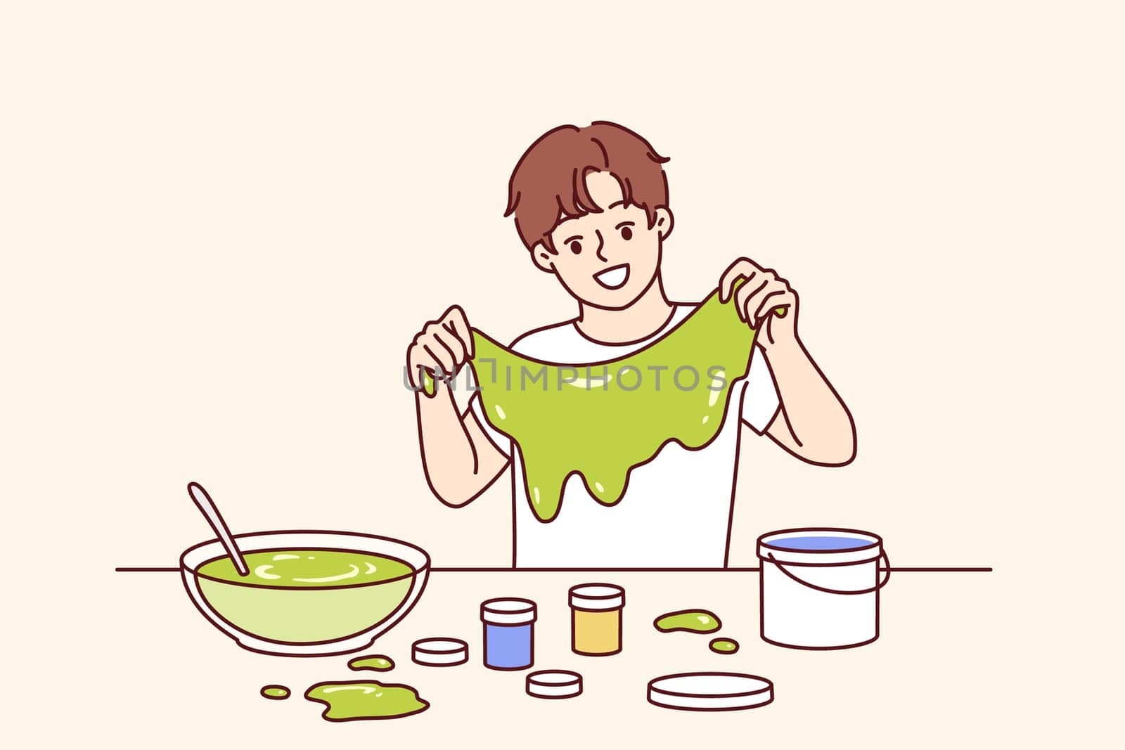 Homemade green slime in hands of boy who made toy thanks to knowledge of chemistry from elementary school. Child independently makes slime substance for fun or to complete assignment from teacher.
