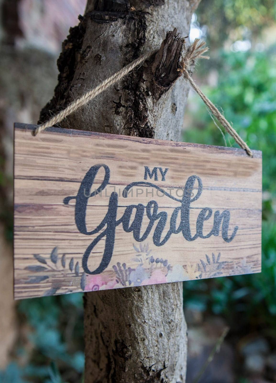 Garden sign with mediterranean courtyard as background. English language letters