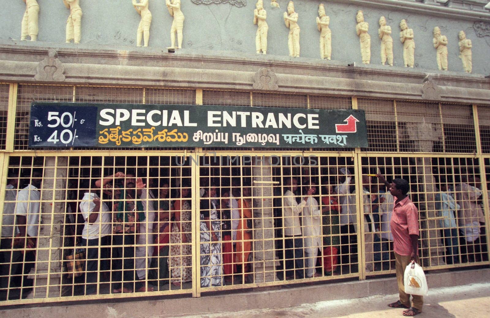 People stand in line at the entrance at the Meenakshi Amman Temple in the city of Madurai in the Province Tamil Nadu in India.  India, Madurai, April, 1998