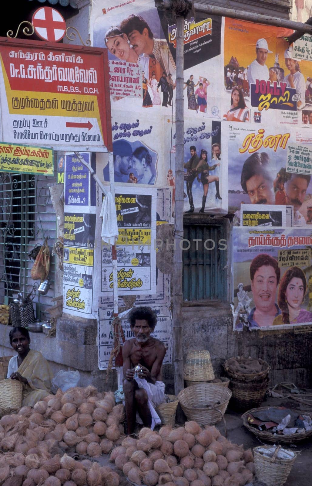 people in a Market street in fron of Bollywood Poster in the city of Madurai in the Province Tamil Nadu in India.  India, Madurai, April, 1998