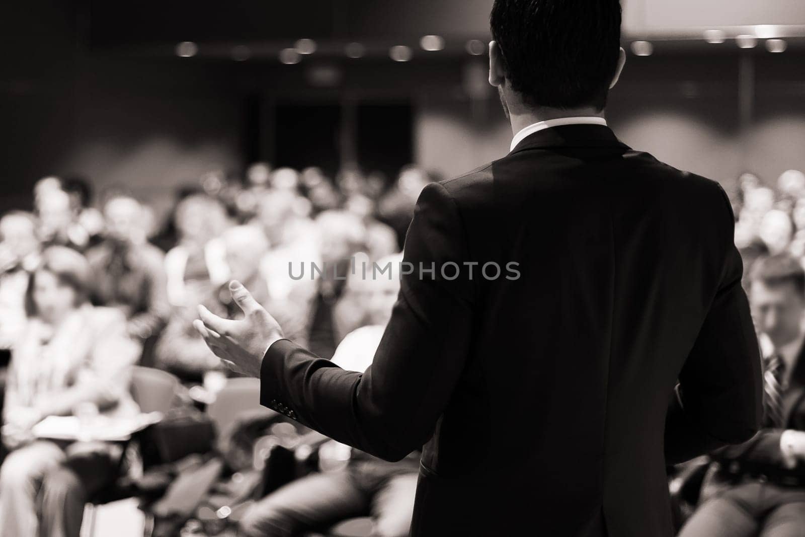 Speaker at Business Conference with Public Presentations. Audience at the conference hall. Entrepreneurship club. Rear view. Horisontal composition. Background blur.