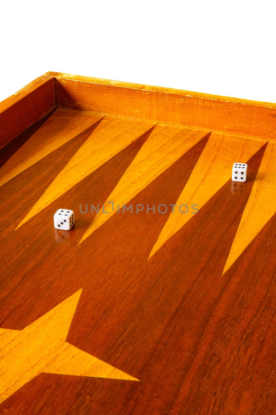 Old varnished wooden board game with plastic checkers and dice. Selective focus with shallow depth of field.