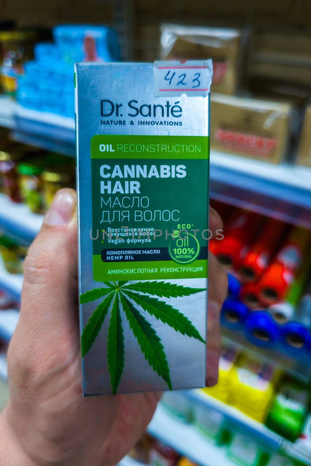 Sokuluk, Kyrgyzstan - April 5, 2024: hand holding box of cannabis hair hemp oil in a small grocery store