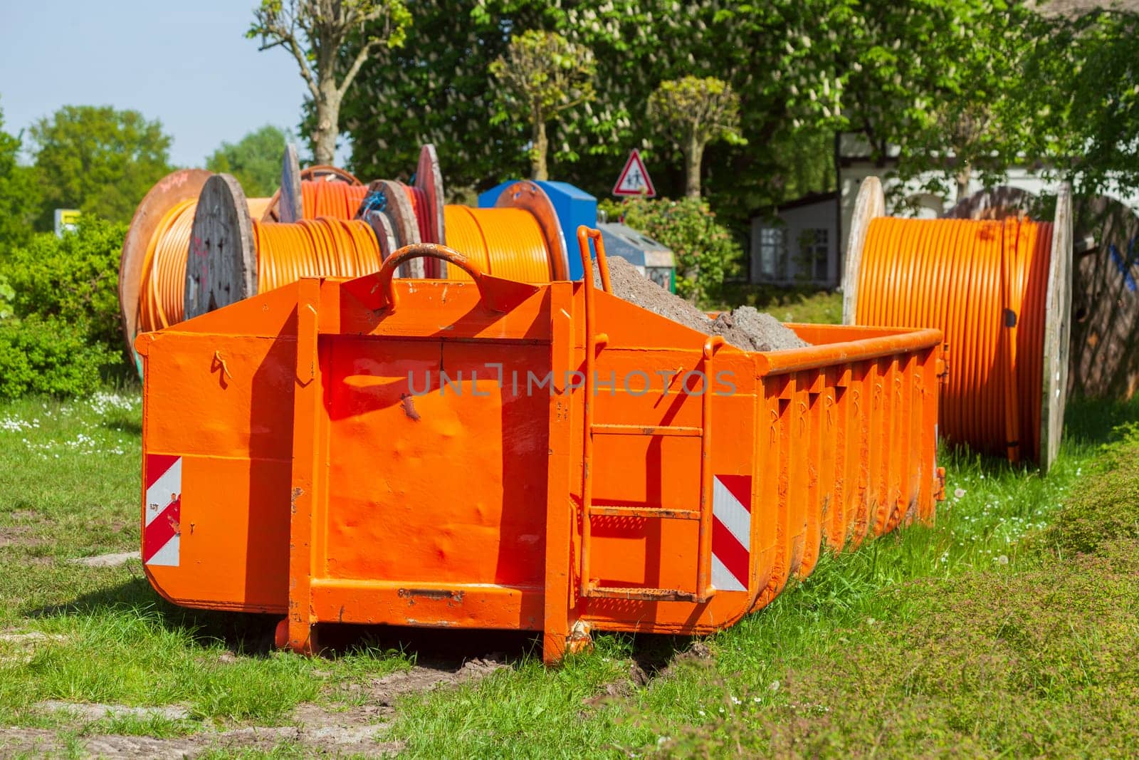 Container, orange skip for building rubble standing on a meadow, Germany