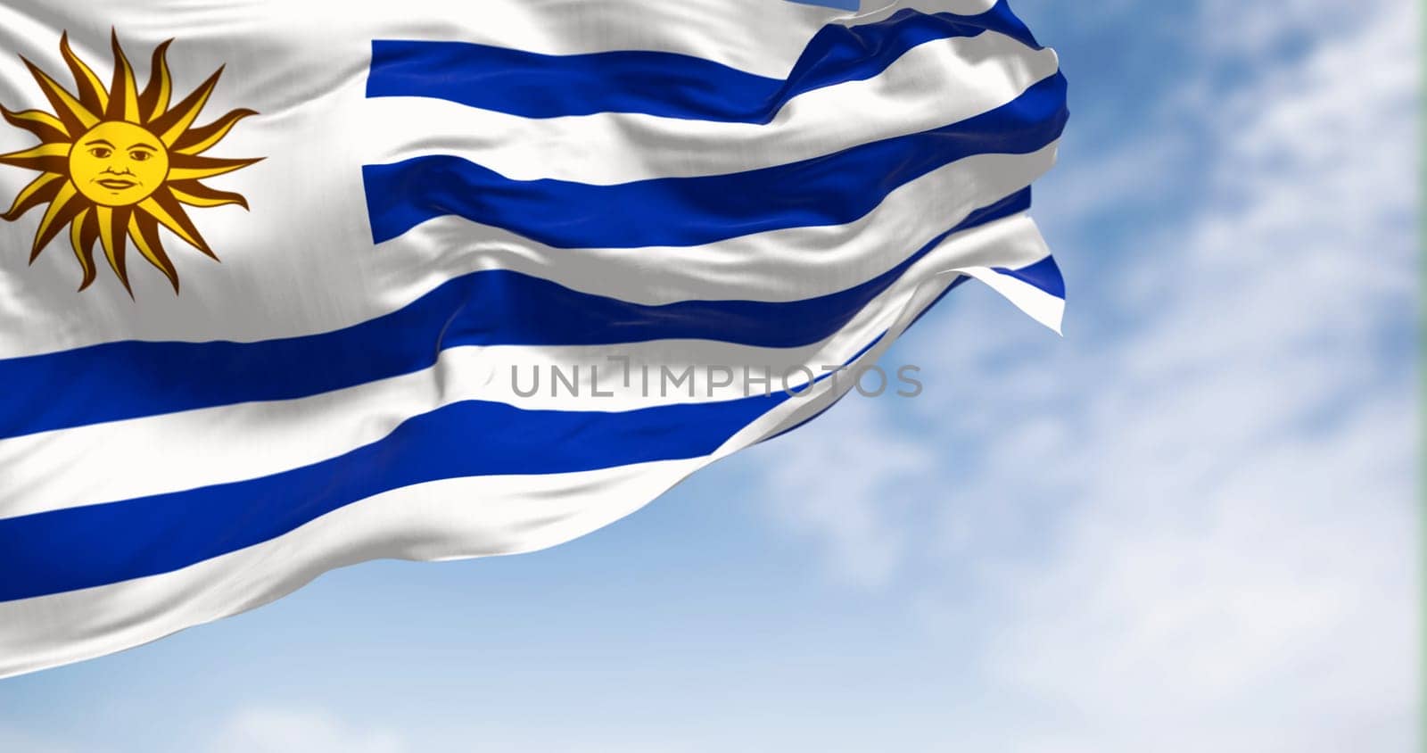 Uruguay national flag fluttering in the wind on a sunny day. 9 horizontal stripes: white and blue alternated, with Sol de Mayo in white square. 3d illustration render.