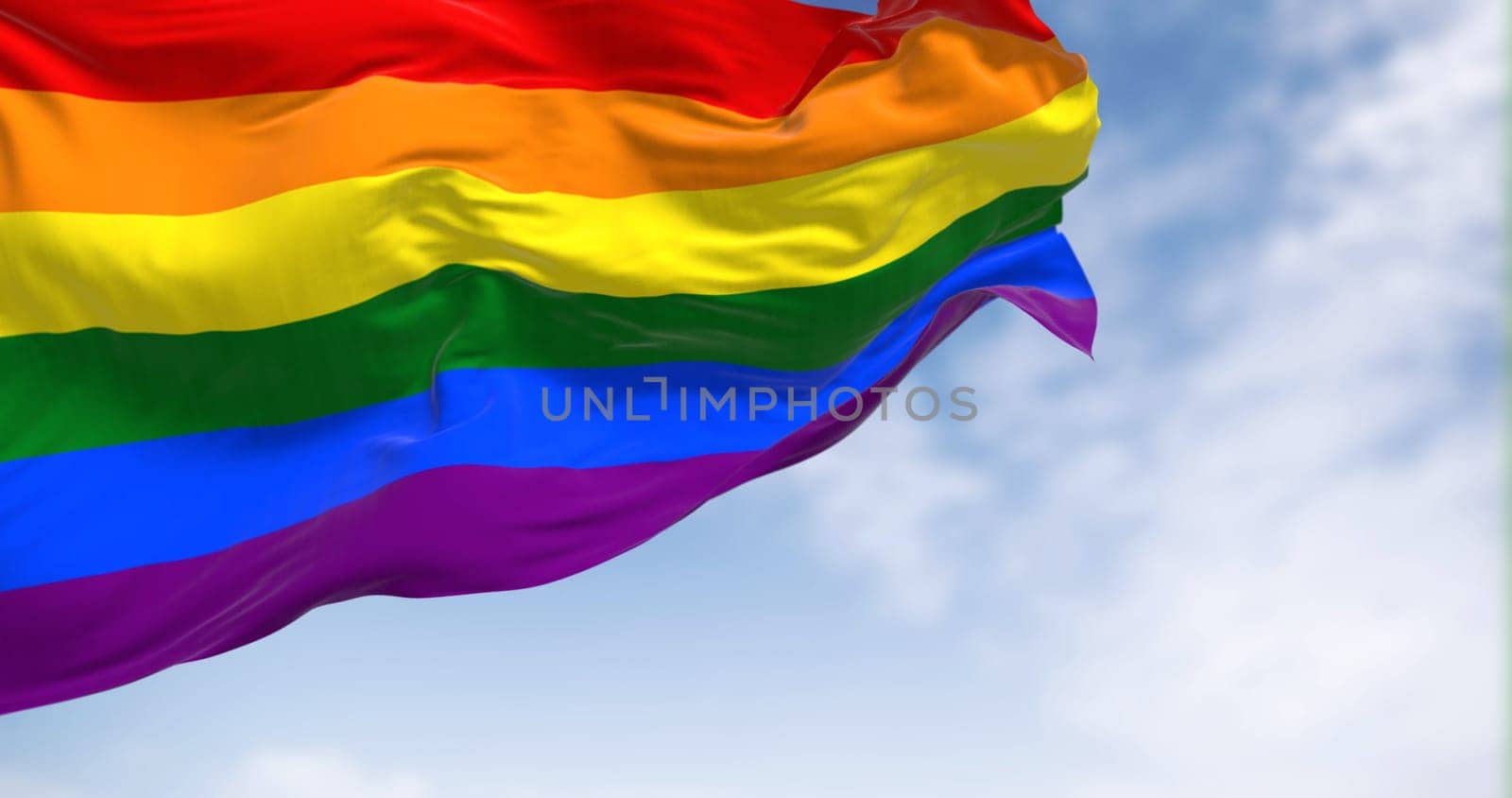 Rainbow flag waving on a clear day. Multicolored flag with stripes in the colors of the rainbow, often used as a symbol of LGBT pride. 3d illustration render. Fluttering fabric