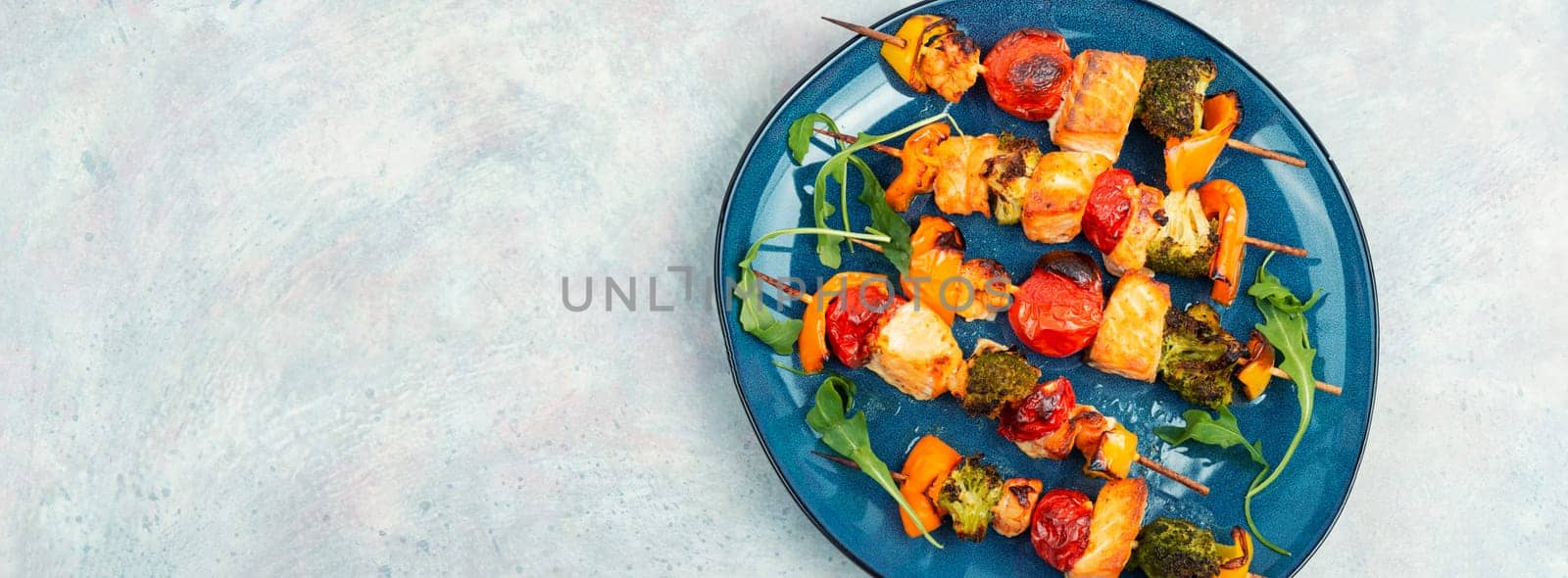Skewers of fish salmon and vegetables on wooden stick. Seafood kebab. Copy space. Long banner.