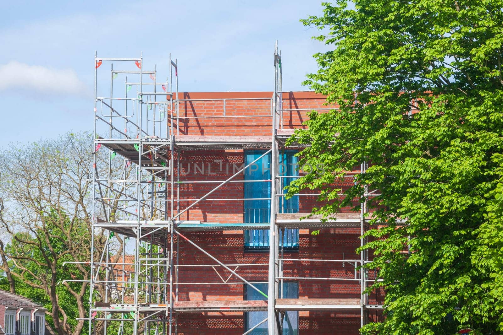 Scaffolding on the shell of a red brick residential building, Germany