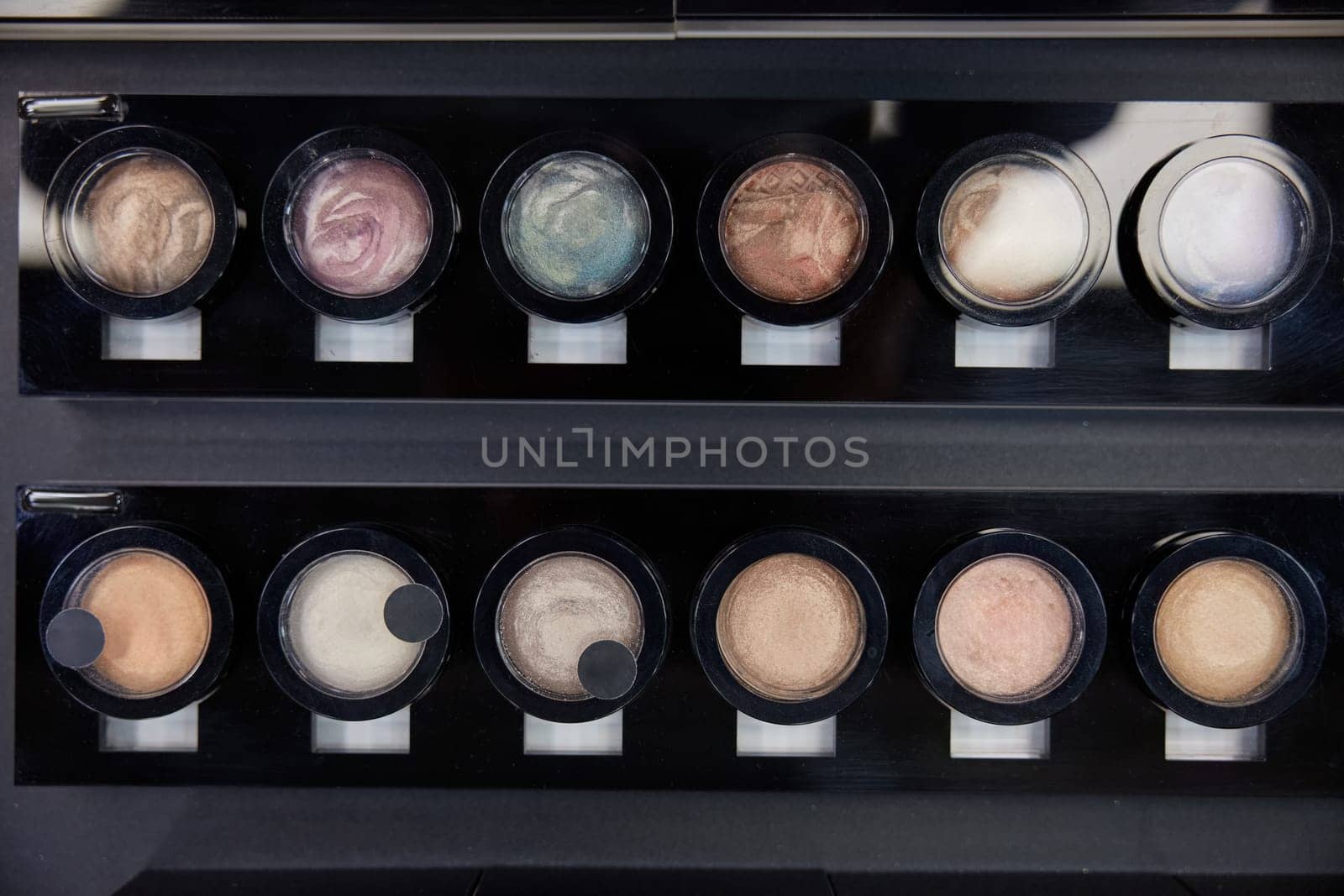 Top view of pearlescent eye shadows in cosmetics shop. Colorful bright decorative products for face
