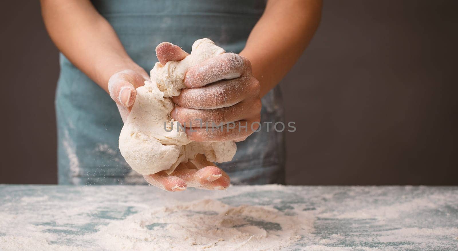 Baker kneading dough for pizza or artisan bread with his hands, prepare ingredients for food, baking pastry