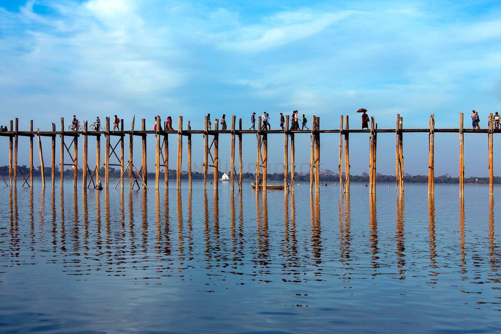 U Bein Bridge at sunset. Amarapura near Mandalay in Myanmar (Burma). The footbridge, over Taungthaman Lake, was constructed in 1849 using reclaimed teak columns by the then mayor of Amarapura, U Bein. It is 1.2Km long.