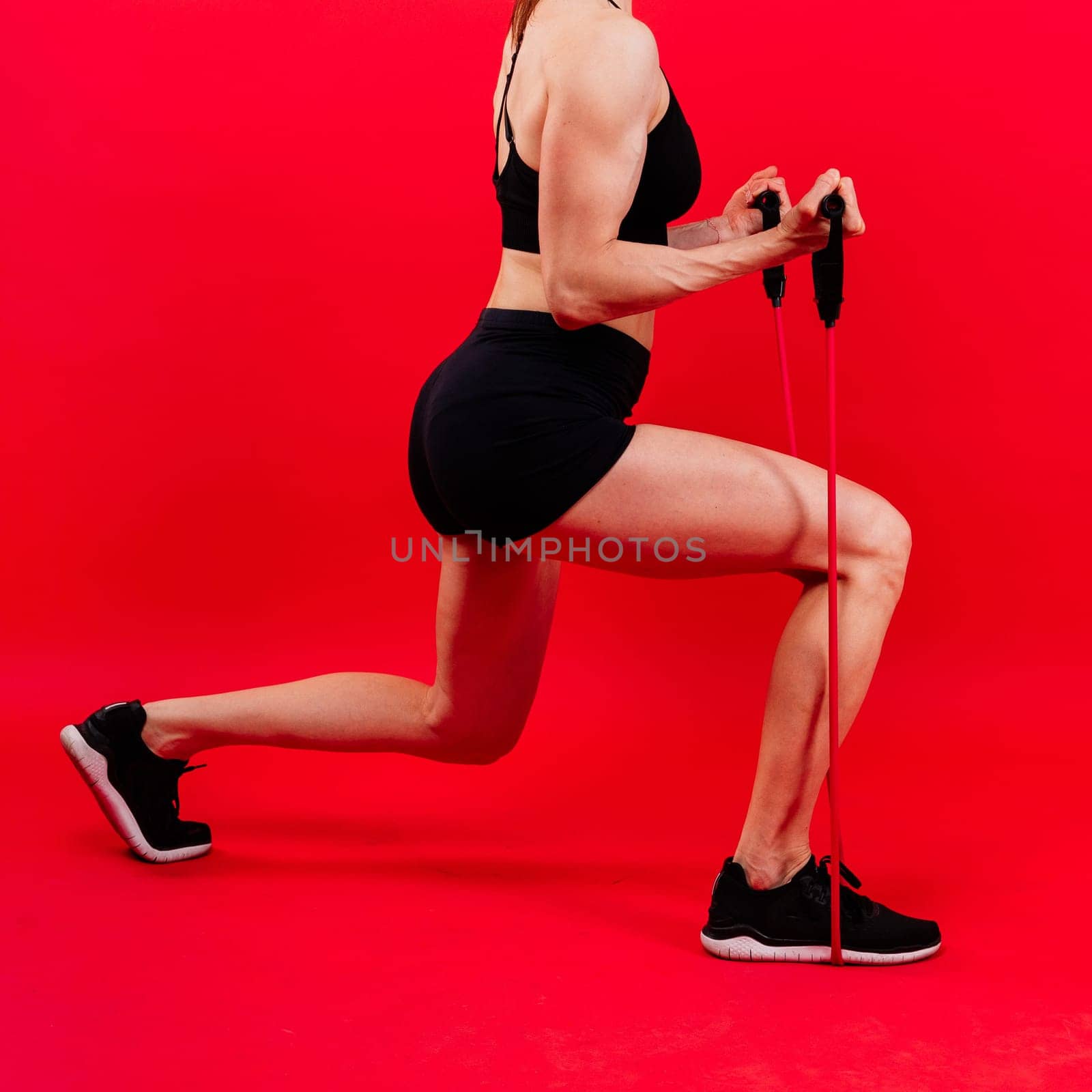 Athletic female performs exercises using resistance band. Strength and motivation