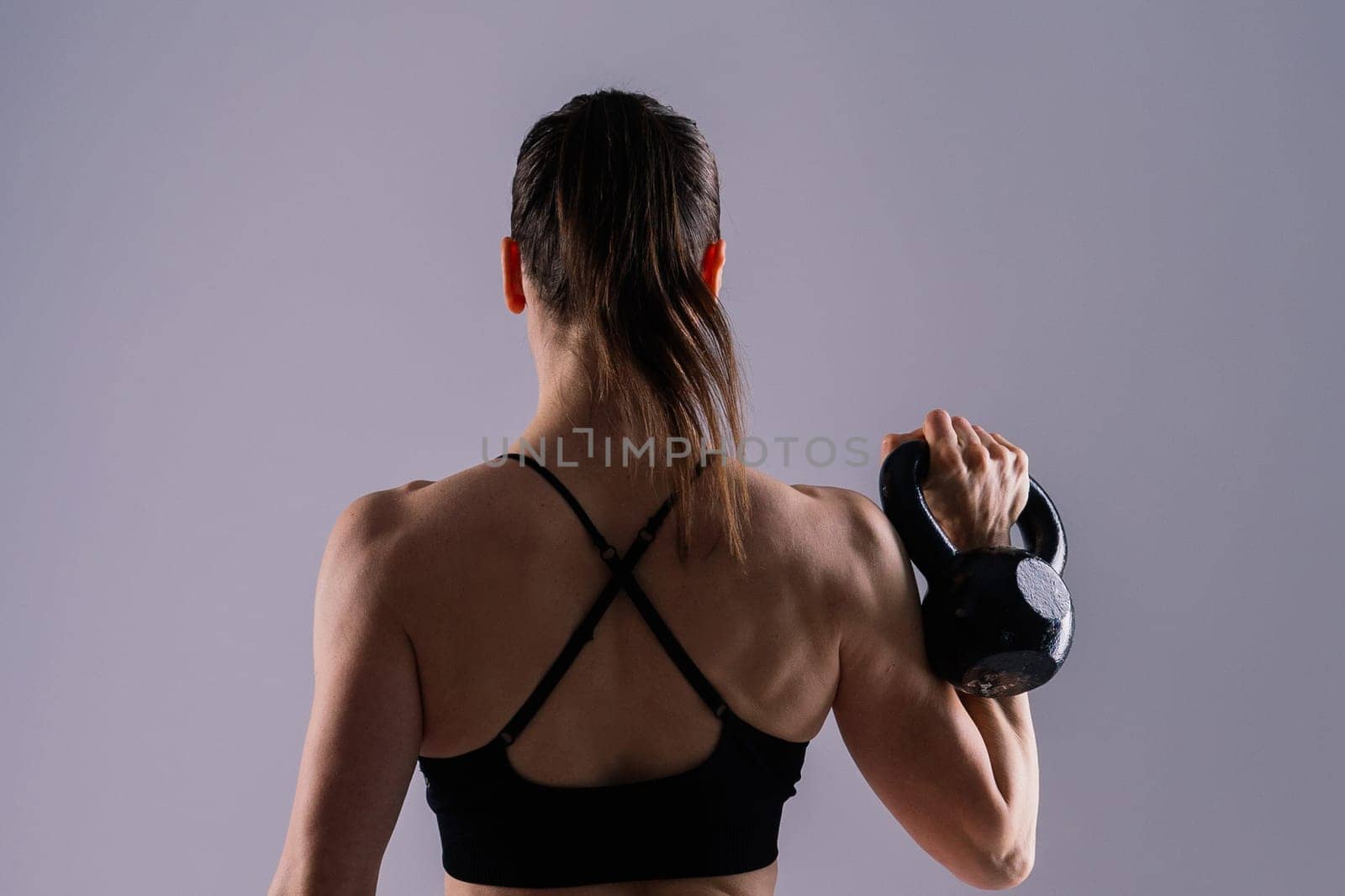 Slim, woman and kettlebell in workout for fitness, exercise and wellness with weight in a studio.