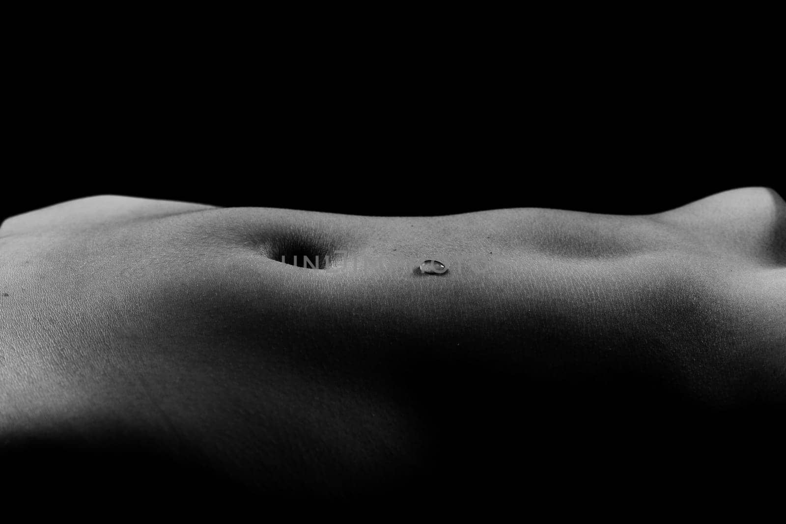 Beautiful female body in honey on a dark background, studio