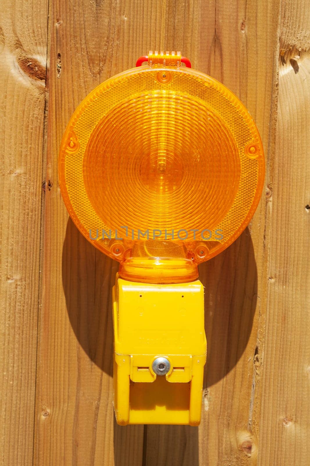 Orange construction site lamp on a site fence, Germany