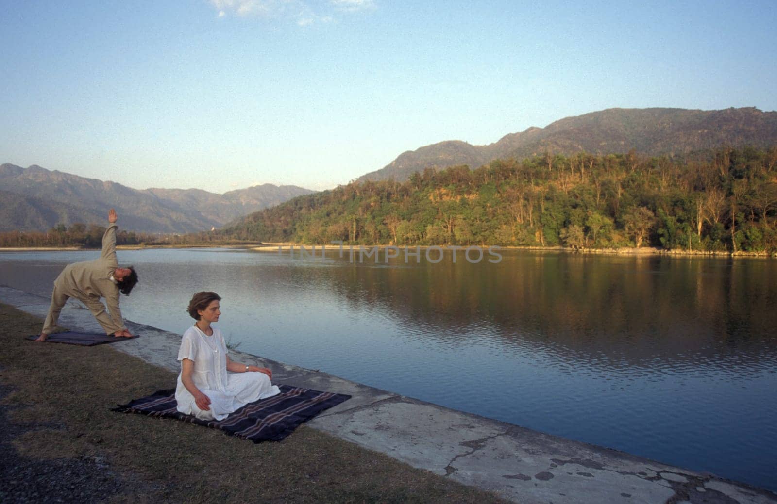 People at a Yoga cless at the Holy Ganges River in the city of Rishikesh in the Province Uttarakhand in India.  India, Rishikesh, February, 1998