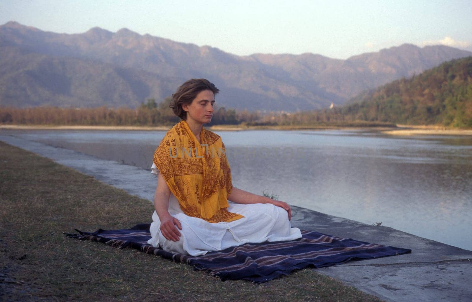 People at a Yoga class at the Holy Ganges River in the city of Rishikesh in the Province Uttarakhand in India.  India, Rishikesh, February, 1998
