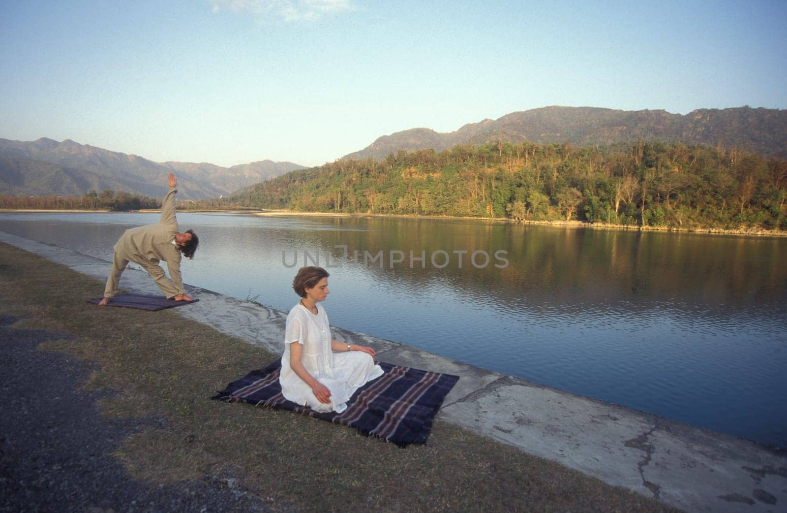People at a Yoga class at the Holy Ganges River in the city of Rishikesh in the Province Uttarakhand in India.  India, Rishikesh, February, 1998