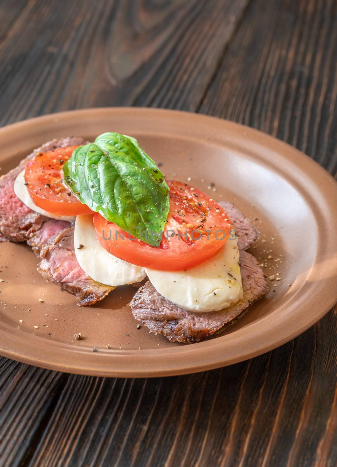 Caprese rib eye steak with mozzarella, tomato and basil