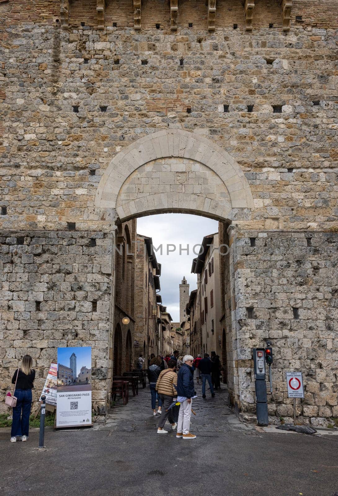 San Gimignano, Italy - Sept 17, 2022: Tourists entering the historic center of San Gimignano via the Porta di San Giovanni. Tuscany, Italy