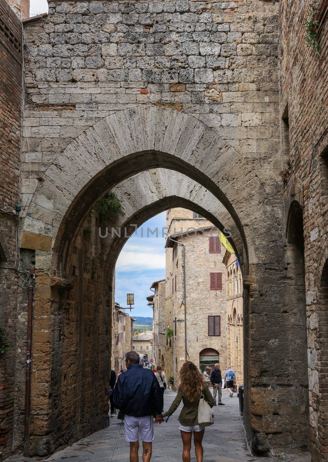 San Gimignano, Italy - Sept 17, 2022: Tourists on Via San Mateo in the medieval town of San Gimingnano. Tuscany, Italy