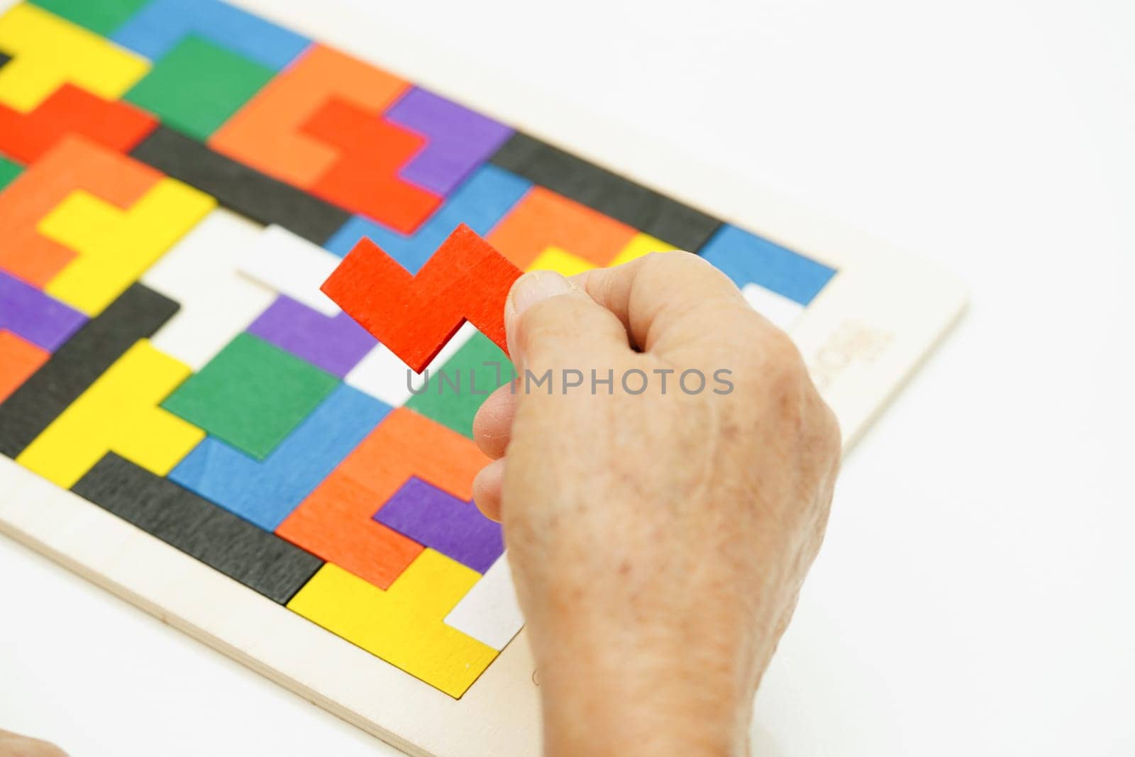 Asian elderly woman playing puzzles game for treatment dementia prevention and Alzheimer disease.