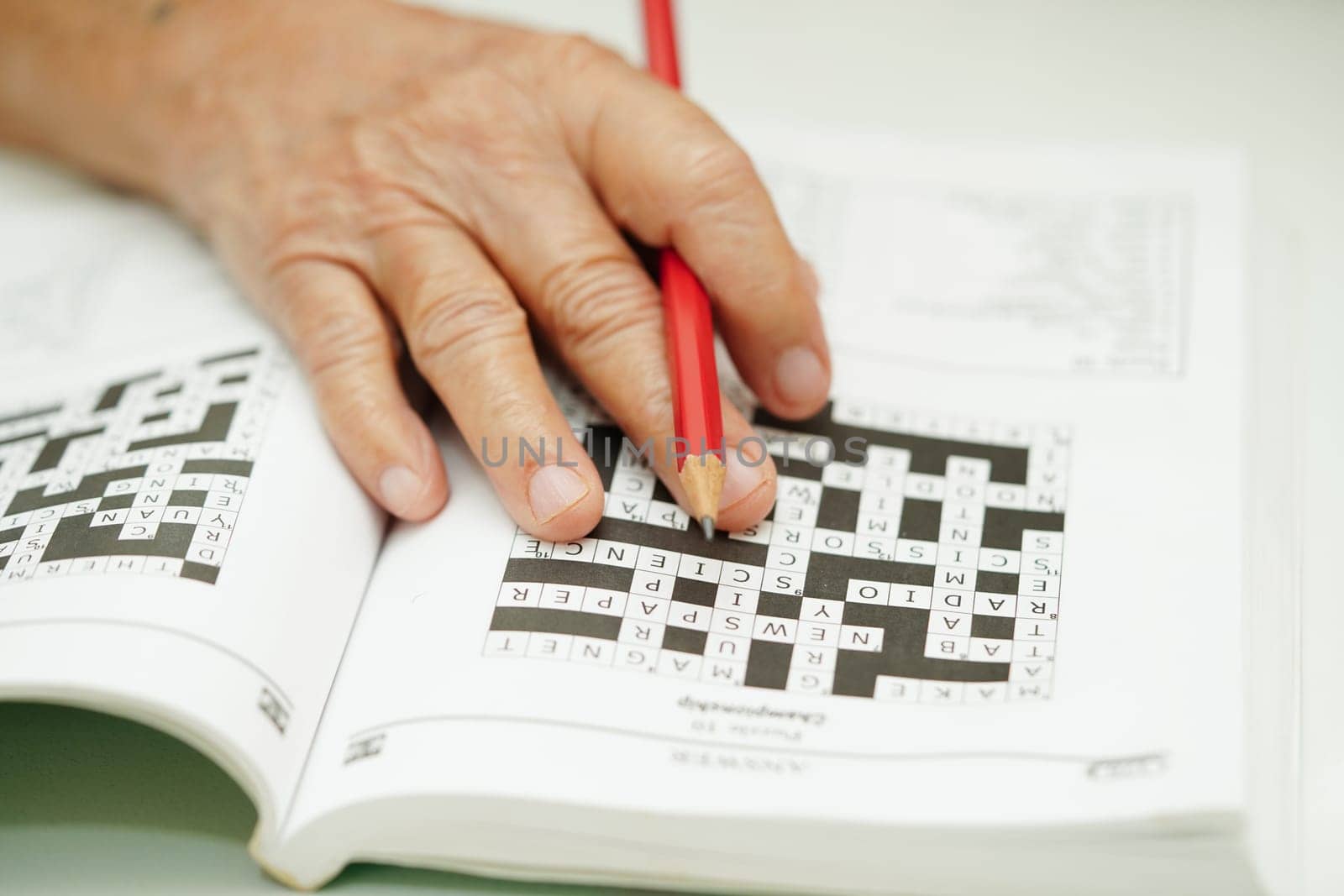 elderly woman playing sudoku puzzle game for treatment dementia prevention and Alzheimer disease.