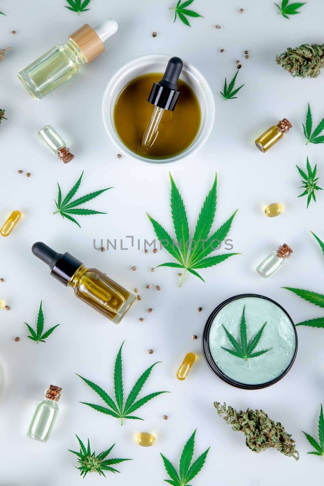 Top view of marijuana leaves and cannabis buds on white background