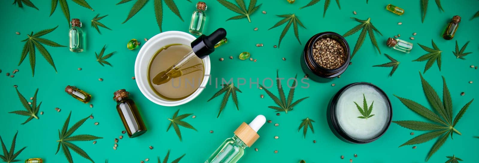Flat lay composition of marijuana and hemp seeds on color green background