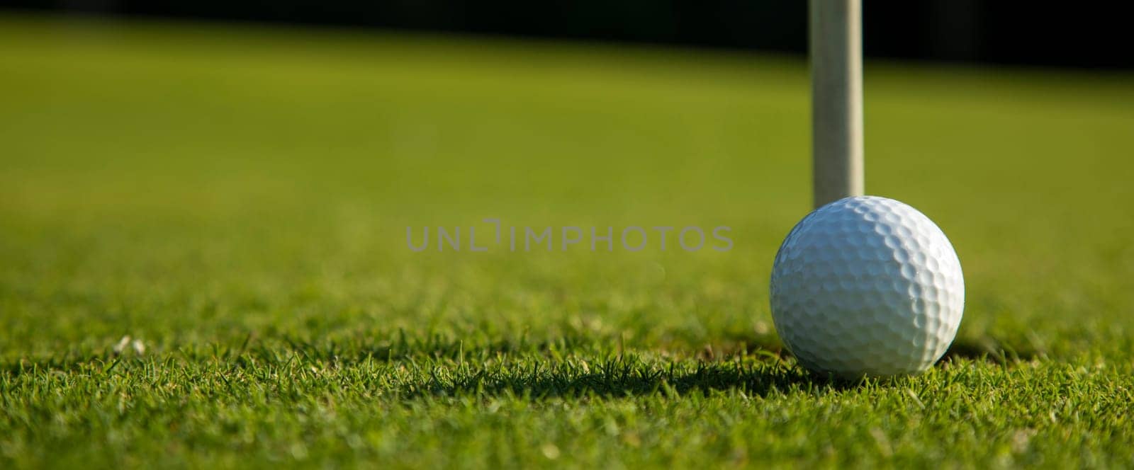 Golf ball and clubs in golf field