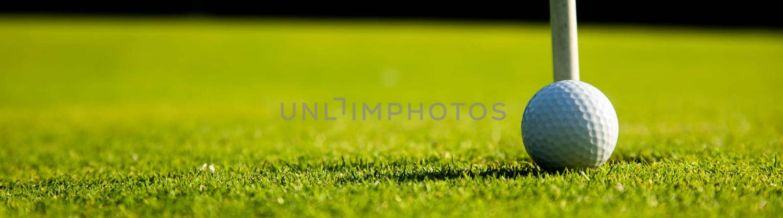 Golf ball and clubs in golf field