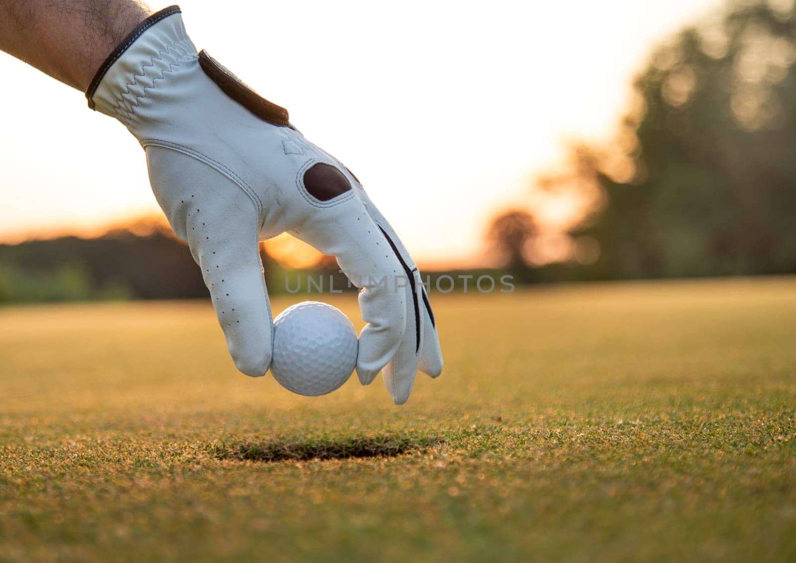 Golf course with ball and grass on close up of a hand     ,grass,golfer,golfing,sky,nature,ball,object,play,blue,fairway,closeup,club,outdoor     ,competition,recreation,background,color,summer