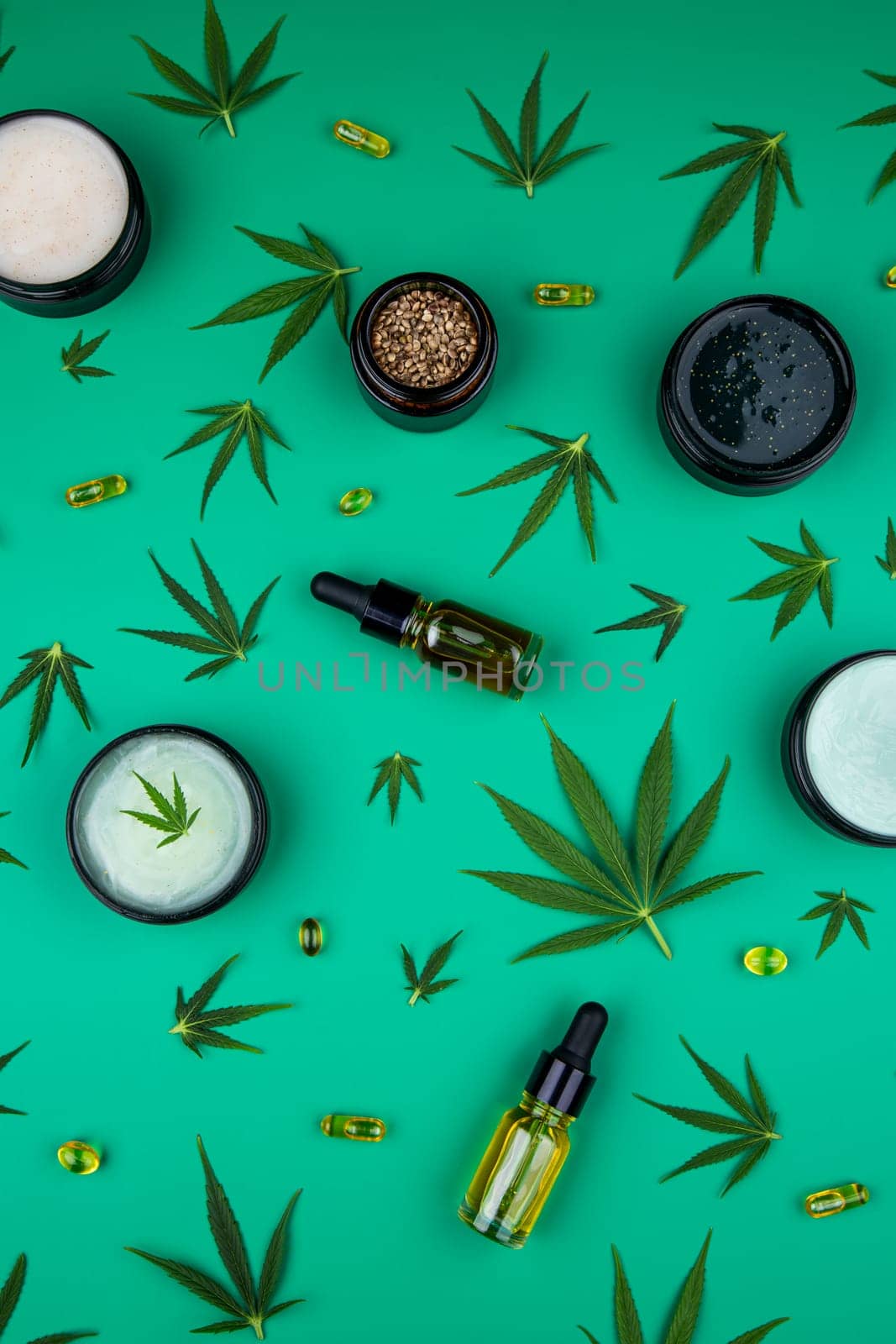 Flat lay composition of marijuana and hemp seeds on color green background